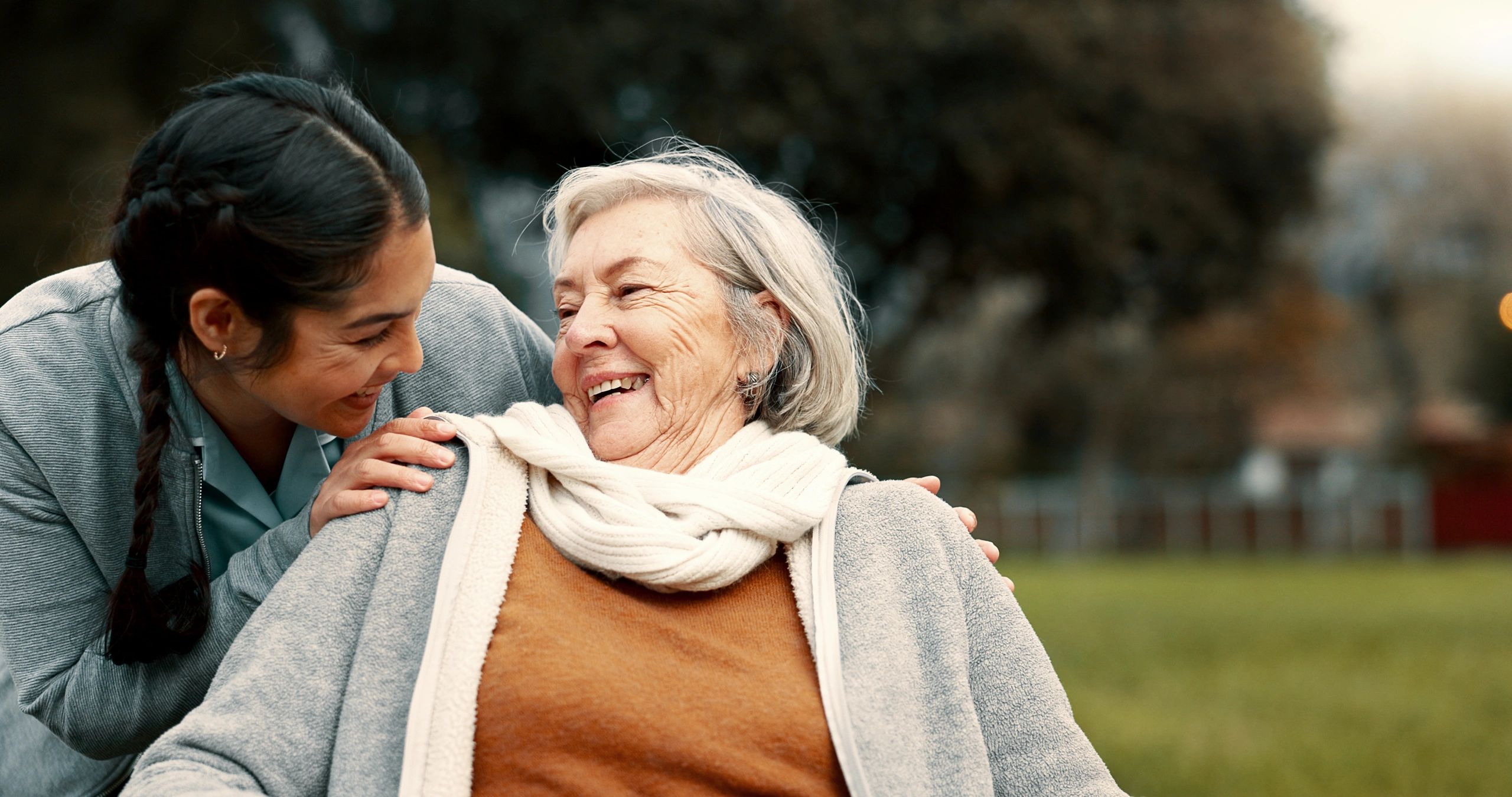 Caregiver helping woman in park